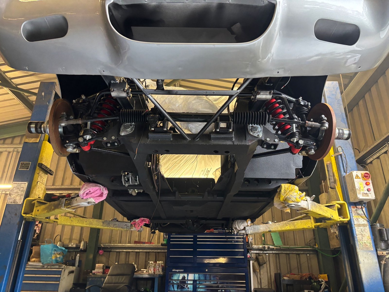 The front suspension and steering rack from below, with the wheels off.