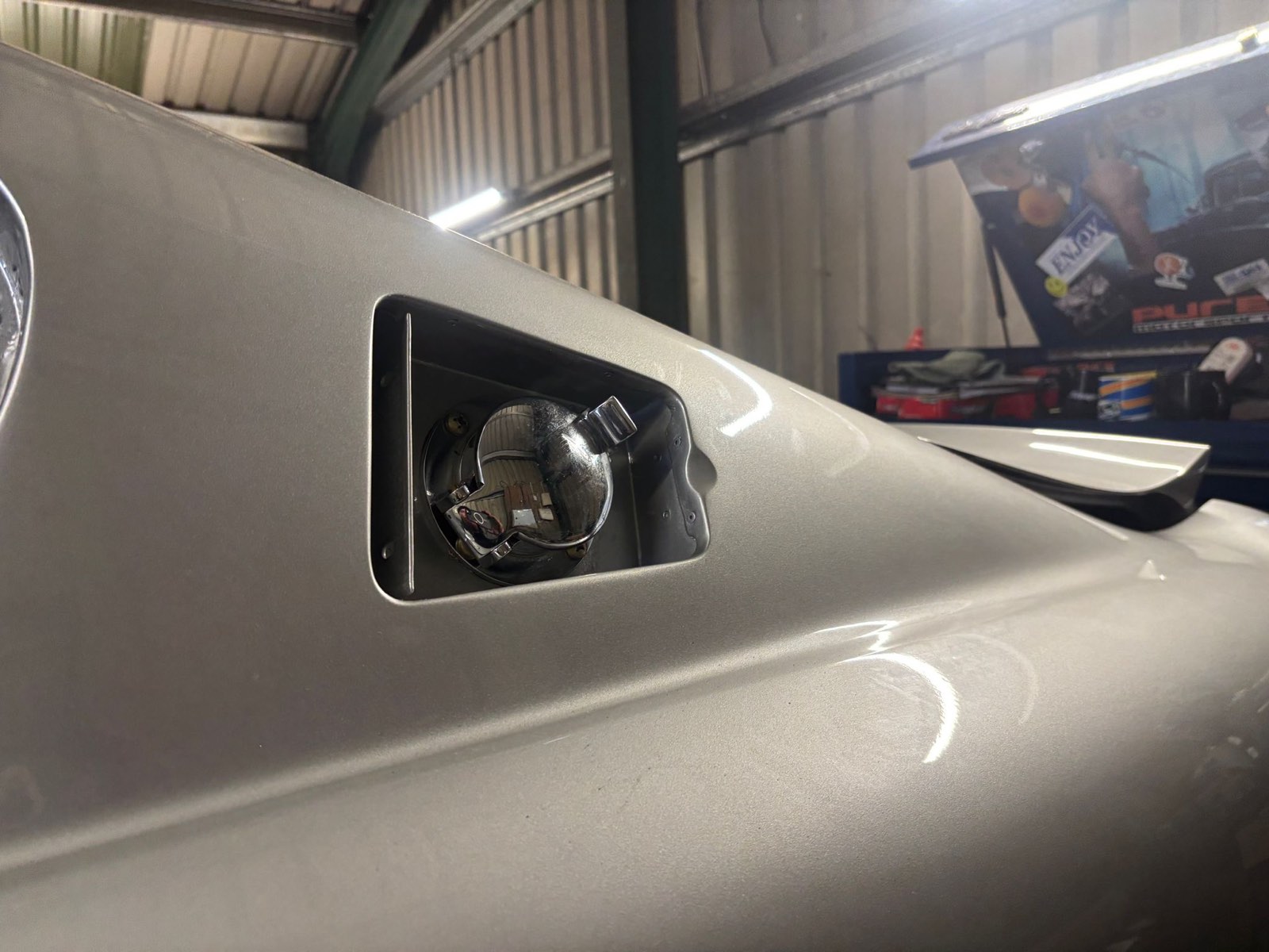 The chrome fuel filler cap in its recess on the rear wing.