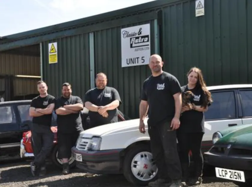 Five of the Classic & Retro Autos team in company T-shirts outside the Unit 5 workshop