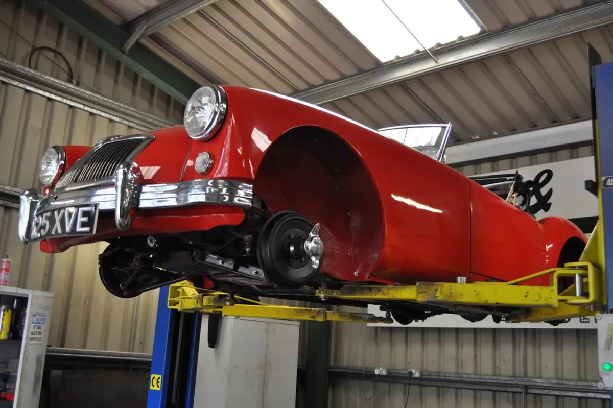 A classic car on the lift during its restoration